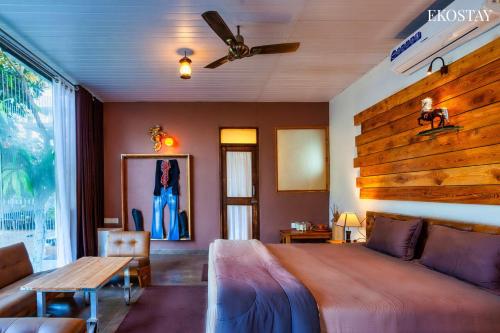a bedroom with a bed and a wooden wall at EKO STAY - The Ranch Villa in Deolāli