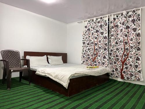 卡尔吉尔Hotel Border View的一间带床和椅子的小卧室