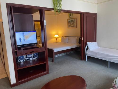 a hotel room with two beds and a tv and a tv stand at RN Service Suites At Times Square KL in Kuala Lumpur