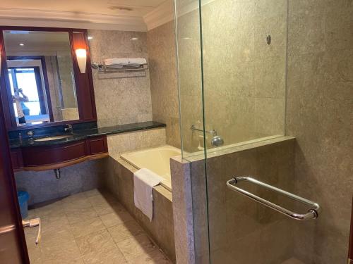 a bathroom with a shower and a sink and a tub at RN Service Suites At Times Square KL in Kuala Lumpur