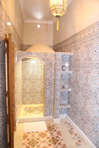 La salle de bains est pourvue d'une douche avec du carrelage bleu et blanc. dans l'établissement Villa BEN - 3chambres, à Marrakech