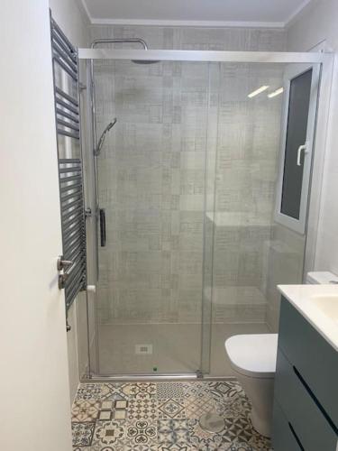 a bathroom with a shower with a toilet and a sink at Villa Jacaranda in Torre-Pacheco
