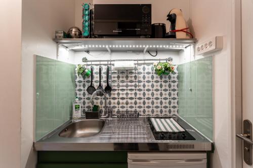 une petite cuisine avec un évier et une cuisinière dans l'établissement Studio calme et accueillant Metro Charonne, à Paris
