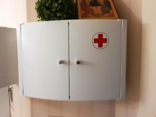 a white cabinet with a red cross on it at Apartament Dzintari in Jūrmala