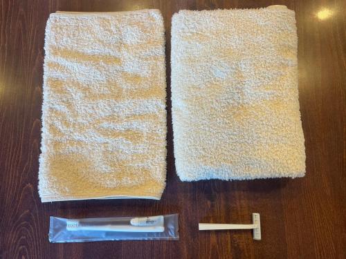 two towels on a wooden table with a toothbrush and a tooth paste at 本栖湖畔 浩庵 Kouan at Lake Motosu in Fujikawaguchiko