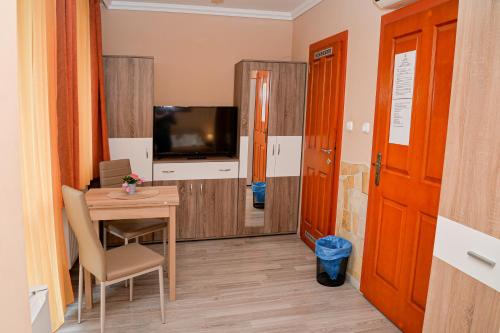 a small dining room with a table and a television at Major Panzió és Étterem in Hajdúszoboszló