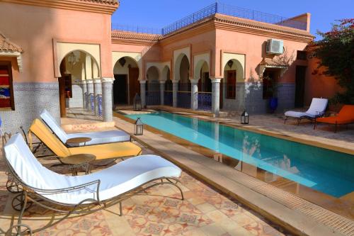 a swimming pool with lounge chairs next to a building at Villa BEN in Marrakesh