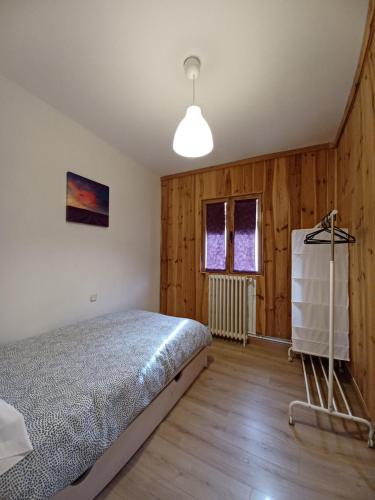 1 dormitorio con 1 cama en una habitación con paredes de madera en VUT Casa de la Catedral Alta, en Sigüenza