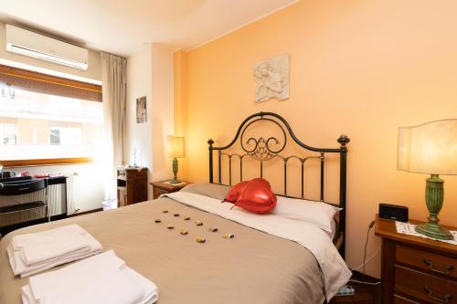 a bedroom with a large bed with a red pillow on it at Rachele’s charming house in the heart of Rome in Rome