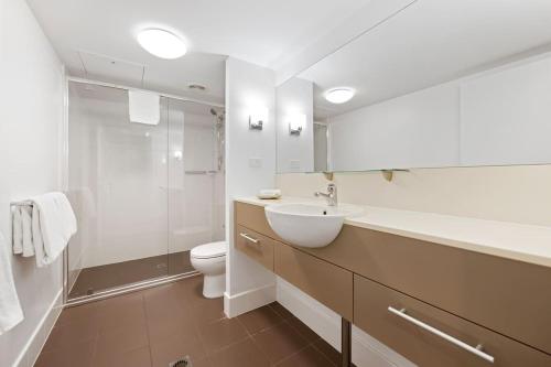 La salle de bains blanche est pourvue d'un lavabo et de toilettes. dans l'établissement Amazing Water View Apartment - Pool, Gym, Parking., à Urangan