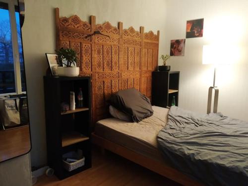une chambre avec un lit avec une tête de lit en bois dans l'établissement Maison 6 pers. à 45 min de Paris, à Ballancourt