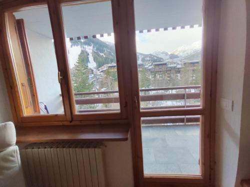 duas janelas num quarto com vista para uma montanha em La MaisonB - Arly em La Thuile