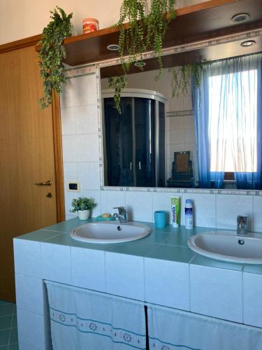 two sinks in a bathroom with two mirrors at Draisina Bike ROOM in Oleggio Castello