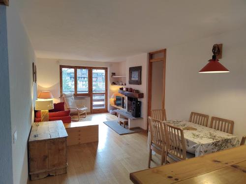 a living room with a table and a dining room at La MaisonB - Arly in La Thuile