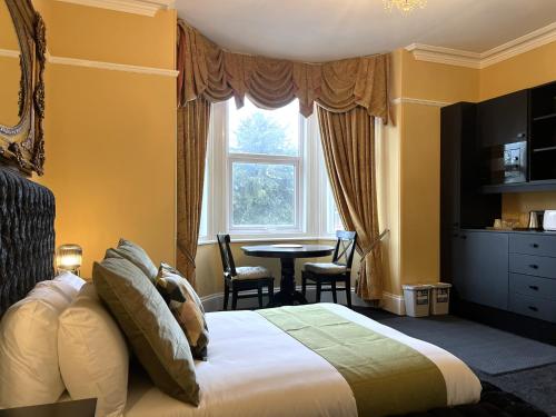 a hotel room with a bed and a table at Melbury Rooms & Studios in Exeter