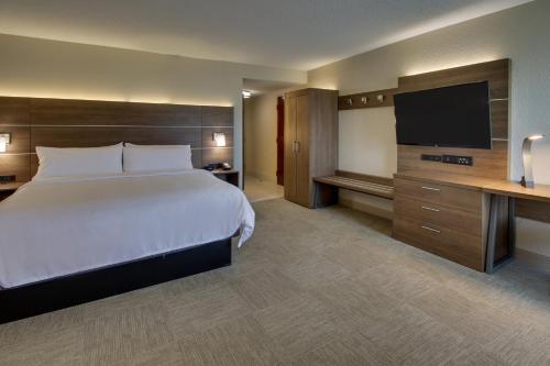 a hotel room with a bed and a flat screen tv at Holiday Inn Express - Horse Cave by IHG in Horse Cave