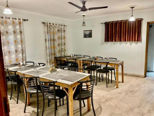 een eetkamer met houten tafels en stoelen bij Hotel Town Centre , Srinagar in Srinagar