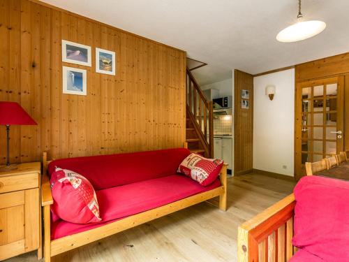 ein rotes Sofa in einem Zimmer mit Holzwänden in der Unterkunft Appartement Val-d'Isère, 5 pièces, 8 personnes - FR-1-519-20 in Val dʼIsère