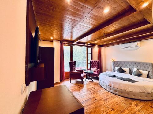 a bedroom with a bed and a desk in a room at The Kasol Parvati View by - ASIA HOLIDAYS in Kasol