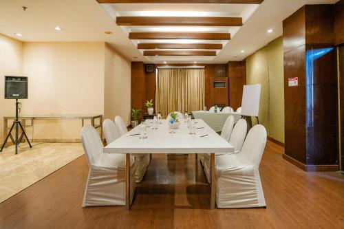 a conference room with a white table and white chairs at Royal Orchid Central Jaipur, Bani Park in Jaipur