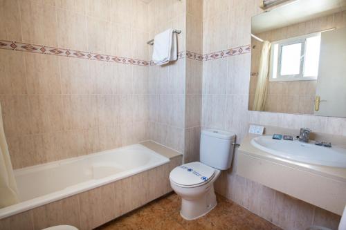 a bathroom with a toilet and a tub and a sink at Hotel Costa Brava in Blanes
