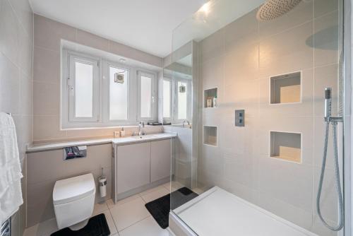 a bathroom with a toilet and a sink and a shower at Relax, Play and Work in London in London