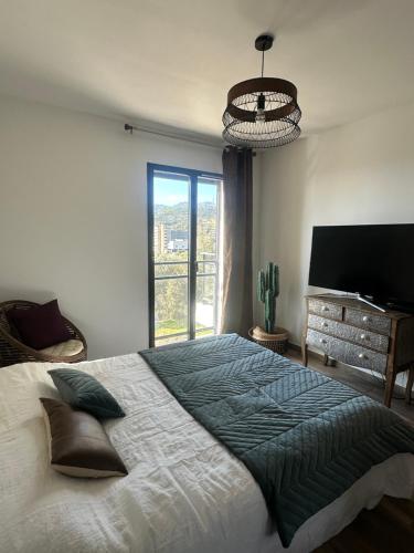 une chambre avec un grand lit et une grande fenêtre dans l'établissement Vue panoramique Mer montagne Bastia, à Bastia