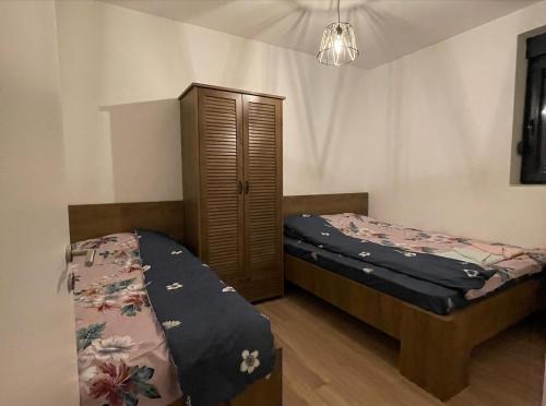 a bedroom with two beds and a cabinet at LonVilla's in Štrpce