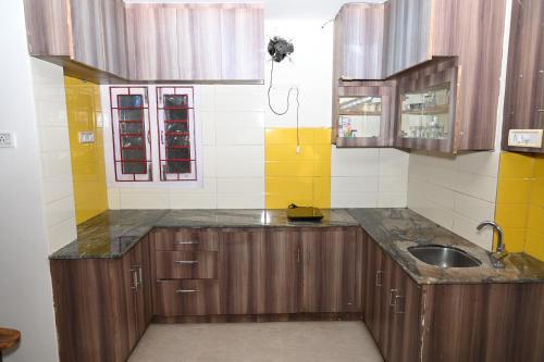 a kitchen with wooden cabinets and a sink at ANDAMAN EXQUISITE in Port Blair