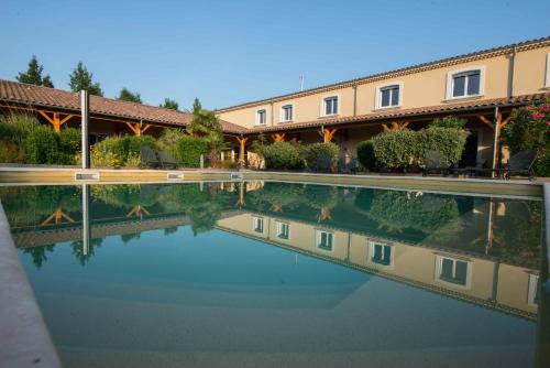 une grande piscine d'eau en face d'un bâtiment dans l'établissement La Saleine, à Crest