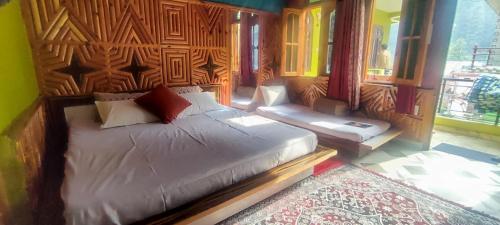 a bedroom with a bed with a wooden head board at Little Hamlet Choj in Kasol