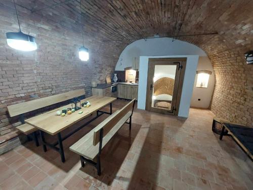 a dining room with benches and a brick wall at Sklipek Popice in Poppitz