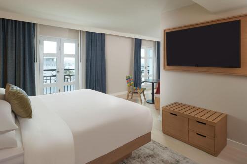 サンファンにあるHotel Rumbao, a Tribute Portfolio Hotelのベッド1台、薄型テレビが備わるホテルルームです。