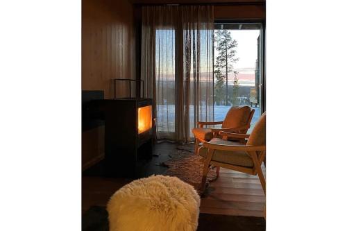sala de estar con sofá, sillas y chimenea en The Riverside Mountain Lodge - 110sqm of Calm Luxury, en Idre