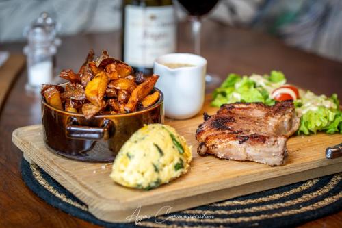 a plate of food with a steak and potatoes on a table at Hôtel Karène in Saint-Paul-lès-Romans