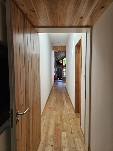 a hallway with wooden flooring and an open door at Casa do Cinzeiro in Nordeste