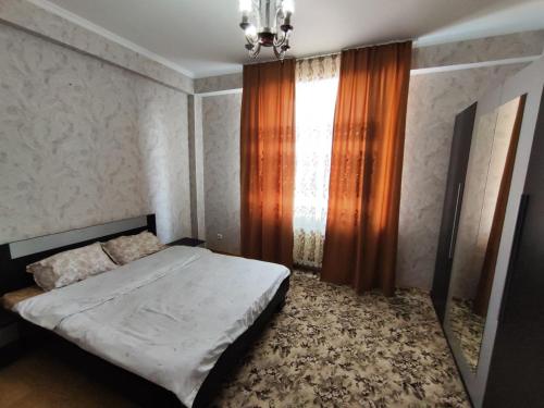 - une petite chambre avec un lit et une fenêtre dans l'établissement Квартира в районе Океан!, à Bishkek