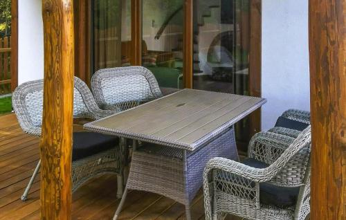 a wooden table and wicker chairs on a porch at Cozy Home In Kopalino With Wifi in Kopalino