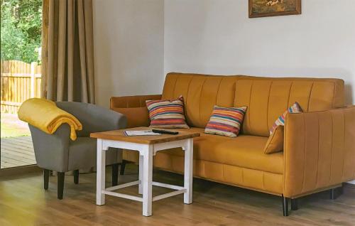 a living room with a yellow couch and a table at Cozy Home In Kopalino With Wifi in Kopalino