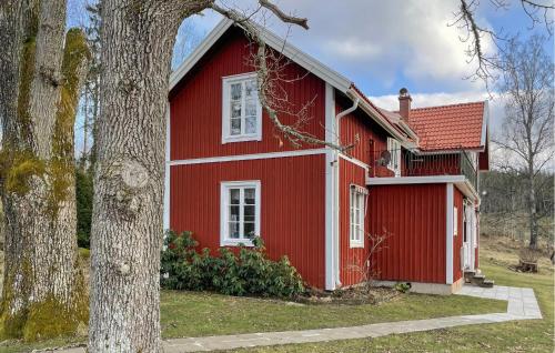 a red house with a tree in front of it at 2 Bedroom Awesome Home In Storfors in Storfors