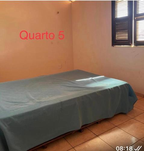 un letto in una stanza con un cartello sul muro di Casa de Praia na Tabuba-Ceará a Caucaia