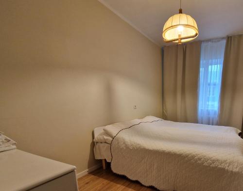 1 dormitorio con cama blanca y ventana en Kooli Apartment Kärdlas en Kärdla