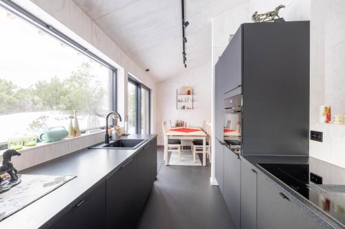 a kitchen with black counters and a large window at Risfjell hytta in Sirevåg