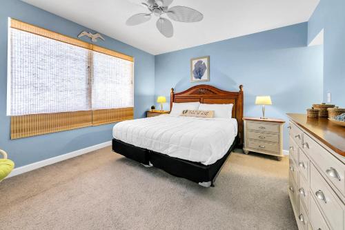 a bedroom with a bed with blue walls and a window at Shores of Panama 1816 in Panama City Beach