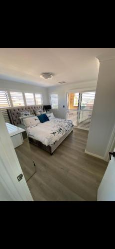 a bedroom with a bed in a room with windows at Hillarys Sea-View Panoramic Living in Perth