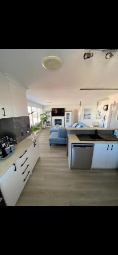 a large kitchen and living room with a blue couch at Hillarys Sea-View Panoramic Living in Perth