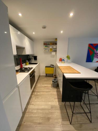 a kitchen with white cabinets and a table in it at The Hoxton Nest - Shoreditch in London