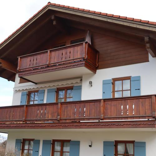 una casa con balcones de madera en la parte superior en FeWo Bader, en Ohlstadt