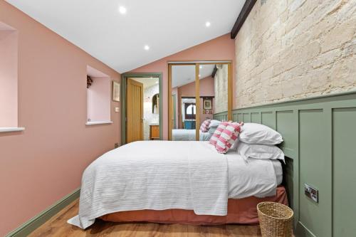 sypialnia z łóżkiem i ceglaną ścianą w obiekcie Copper Beech Cottage w mieście Oakham