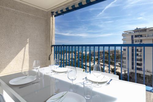 a white table with wine glasses on a balcony at ApartUP Patacona Infinity in Valencia